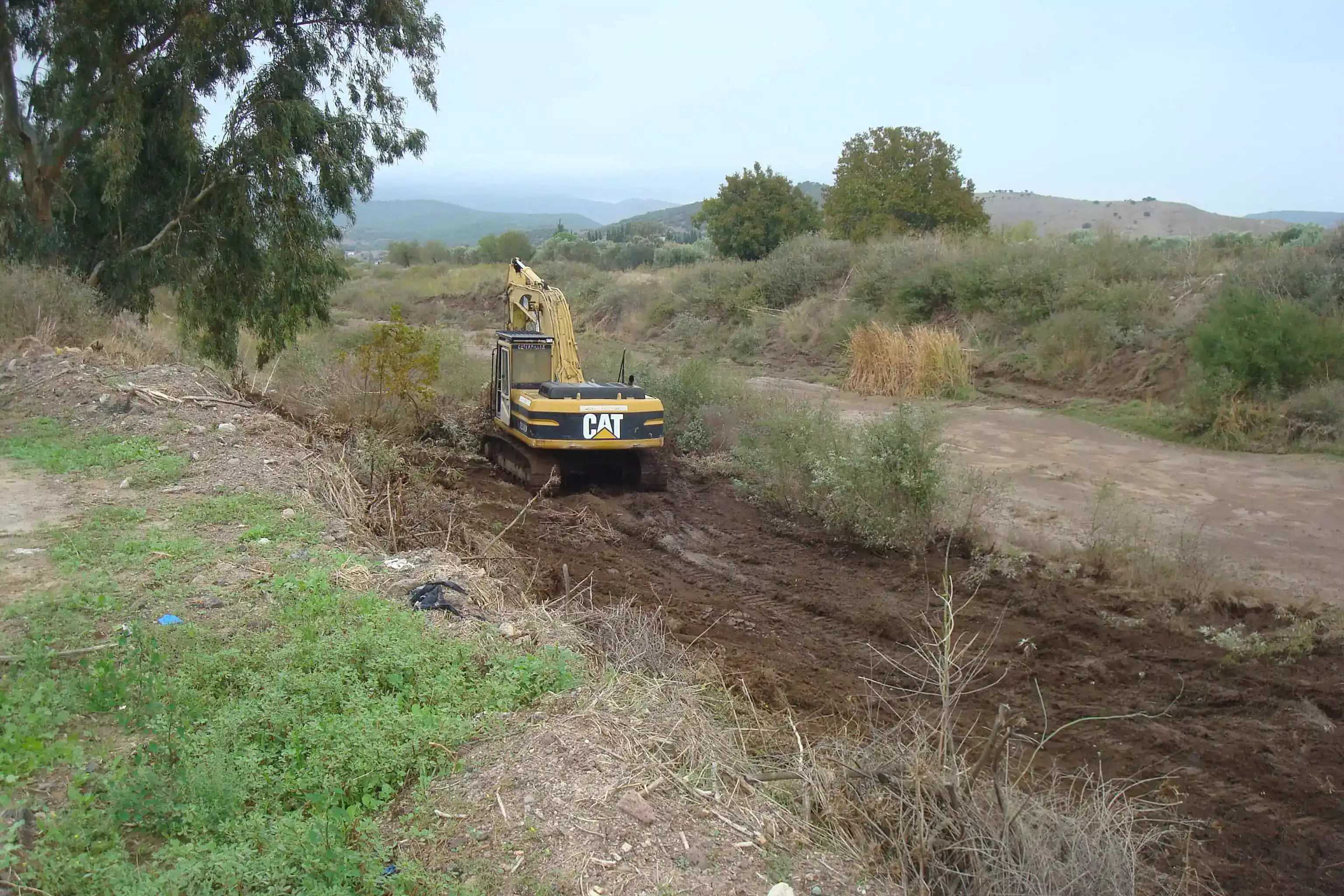 Καθαρισμένος χείμαρος χωρίς ξερά, χωρίς επιπλέον πρανοί και χωρίς φερτά υλικά. Στο κέντρο του χειμάρου απεικονίζεται ένας εκσκαφέας τύπου Caterpillar.